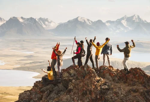"Group of hikers on mountain summit with panoramic alpine views"
