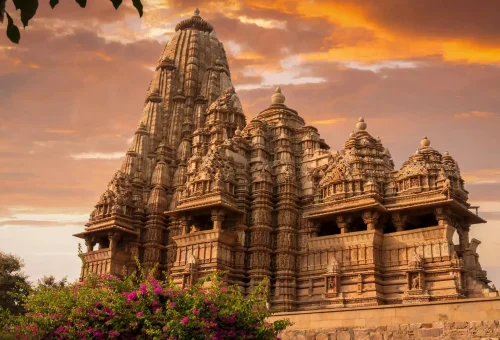 "Khajuraho temple in India at sunset with intricate ancient architecture"