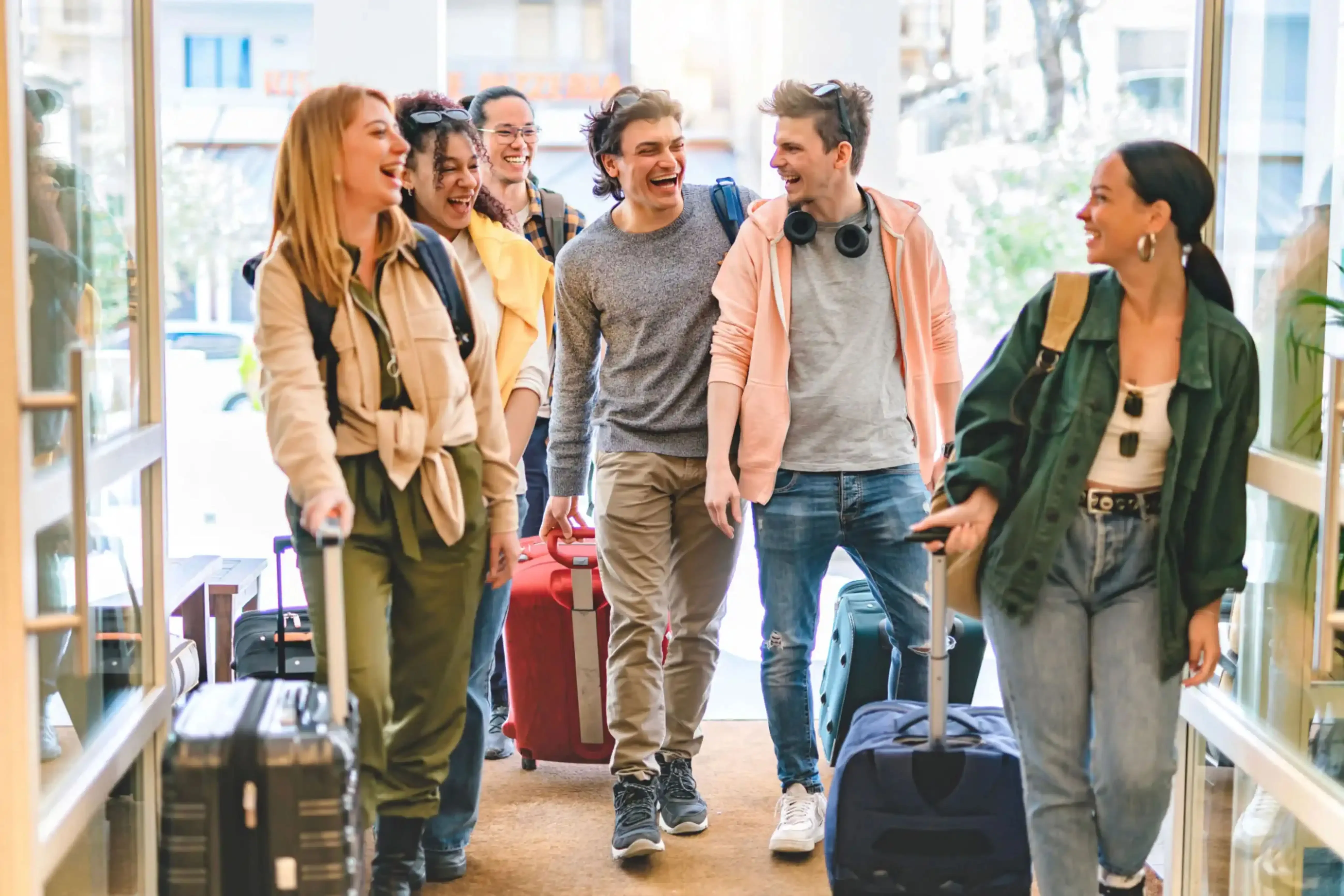 "Group of young travelers walking with luggage at airport terminal"