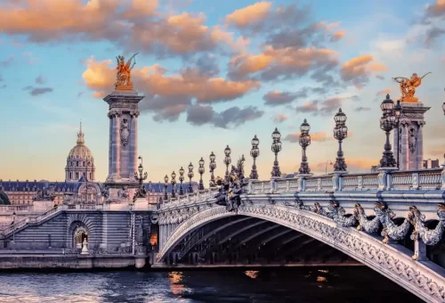 "Pont Alexandre III bridge in Paris with ornate sculptures at sunset"