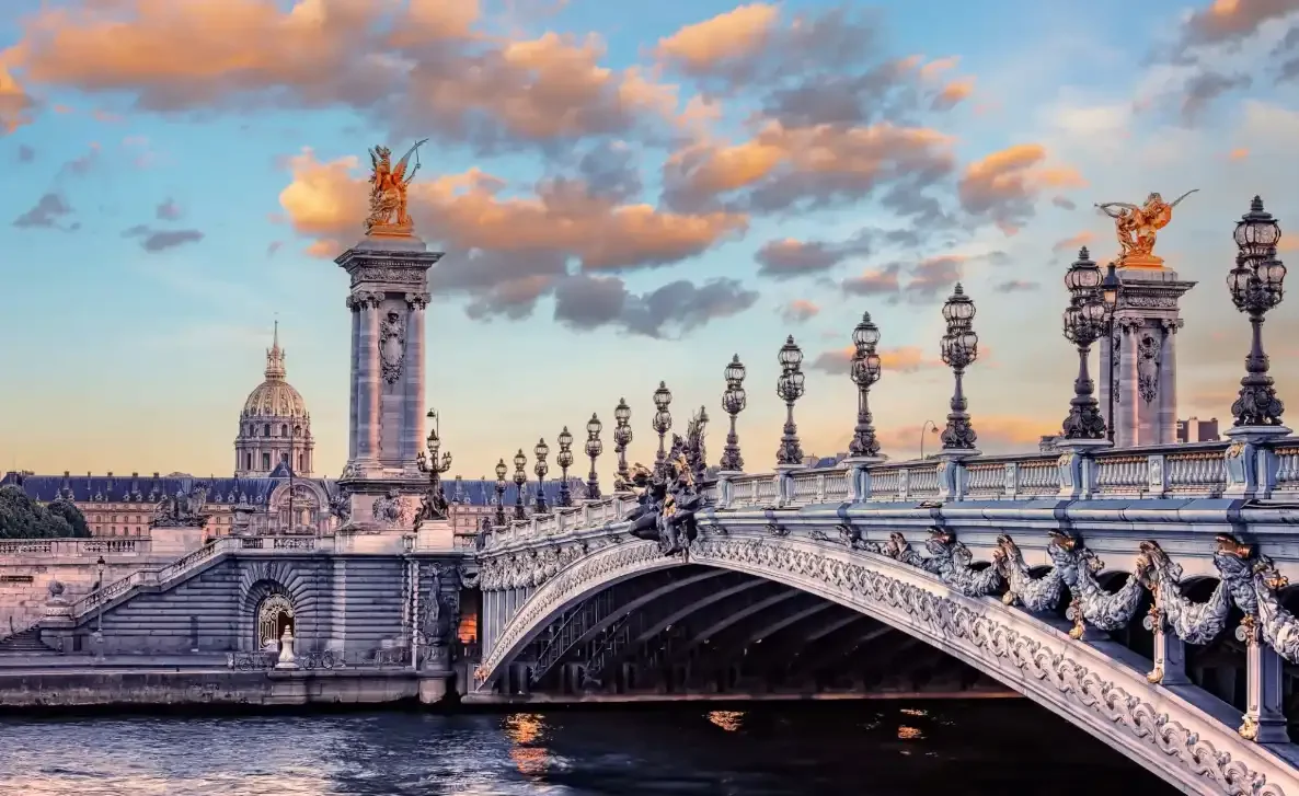 "Pont Alexandre III bridge in Paris with ornate sculptures at sunset"
