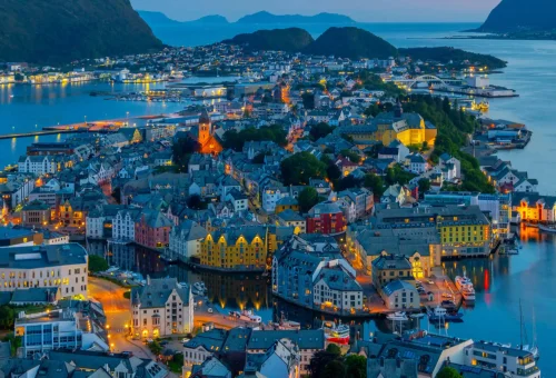 "Scenic aerial view of Ålesund, Norway at dusk with colorful Nordic architecture and surrounding fjords"