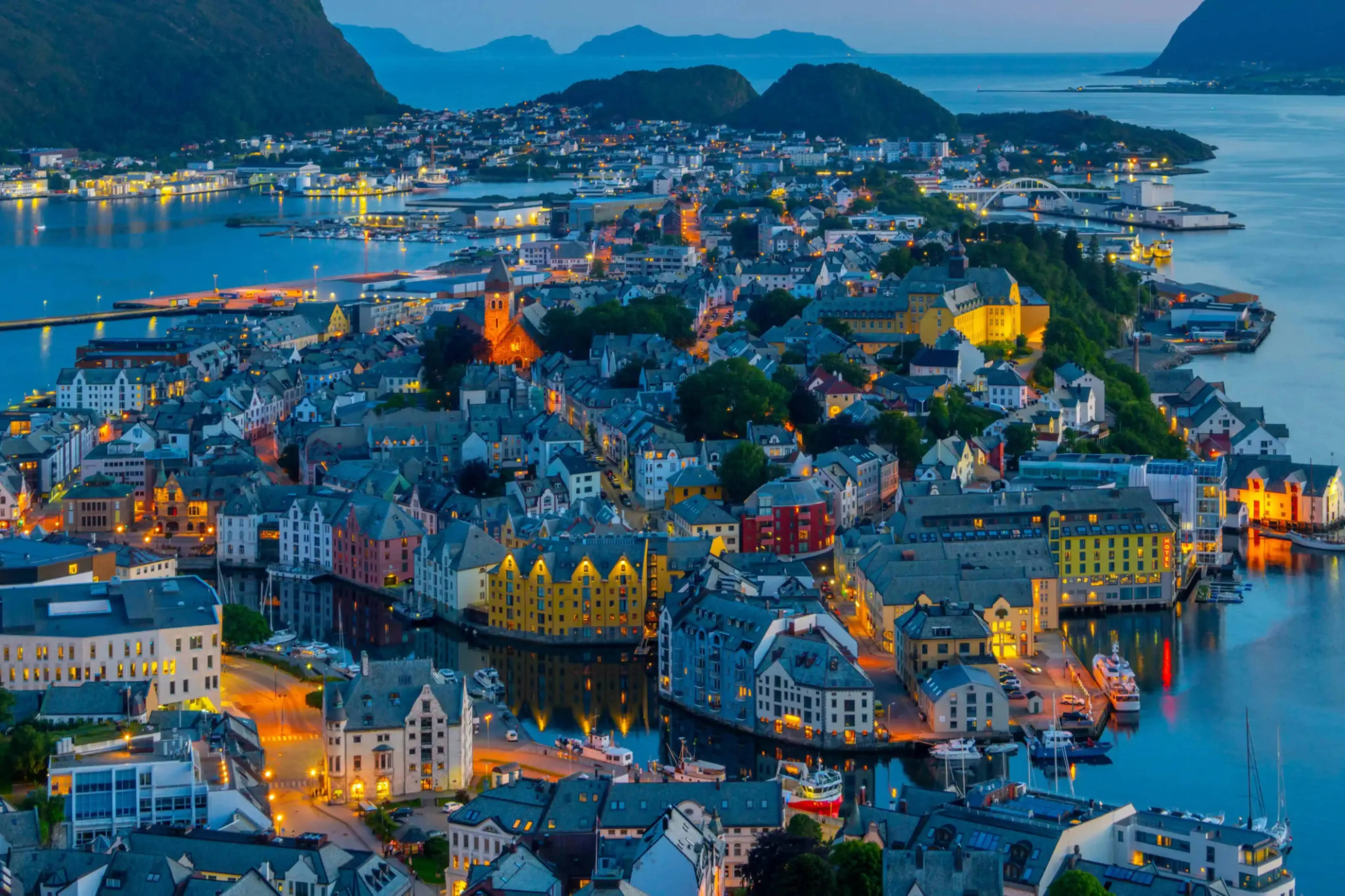 "Scenic aerial view of Ålesund, Norway at dusk with colorful Nordic architecture and surrounding fjords"