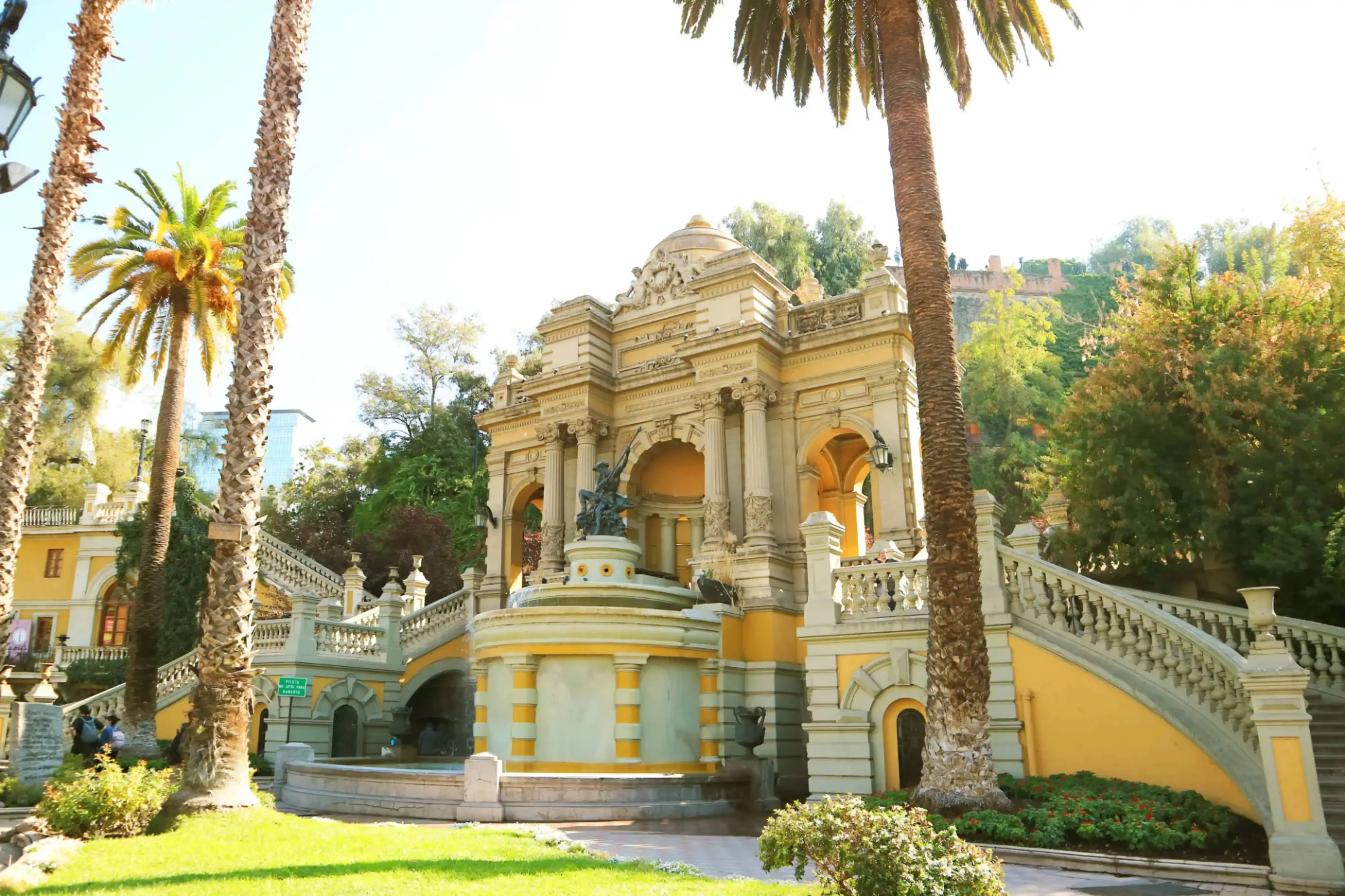 "Neptune Fountain and grand staircase at Cerro Santa Lucía park in Santiago, Chile, surrounded by palm trees and lush greenery."