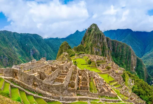 "Machu Picchu, the ancient Incan citadel nestled in the Andes Mountains of Peru, with terraced stone ruins and Huayna Picchu peak in the background."