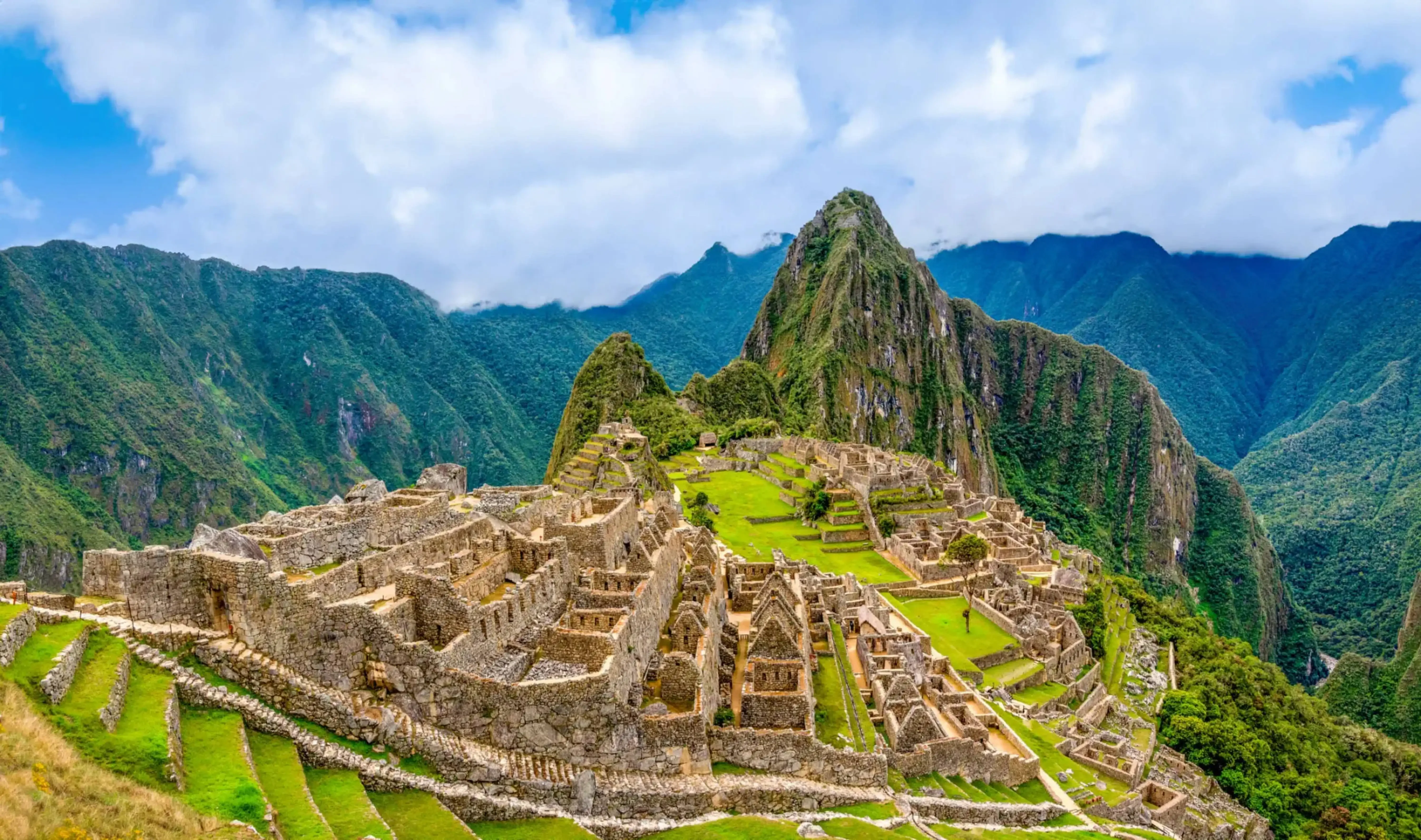 "Machu Picchu, the ancient Incan citadel nestled in the Andes Mountains of Peru, with terraced stone ruins and Huayna Picchu peak in the background."