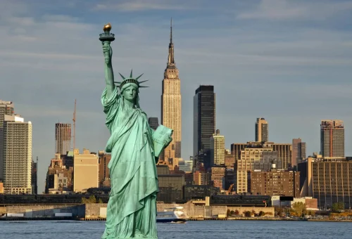 "Statue of Liberty with New York City skyline and Empire State Building in the background, USA."