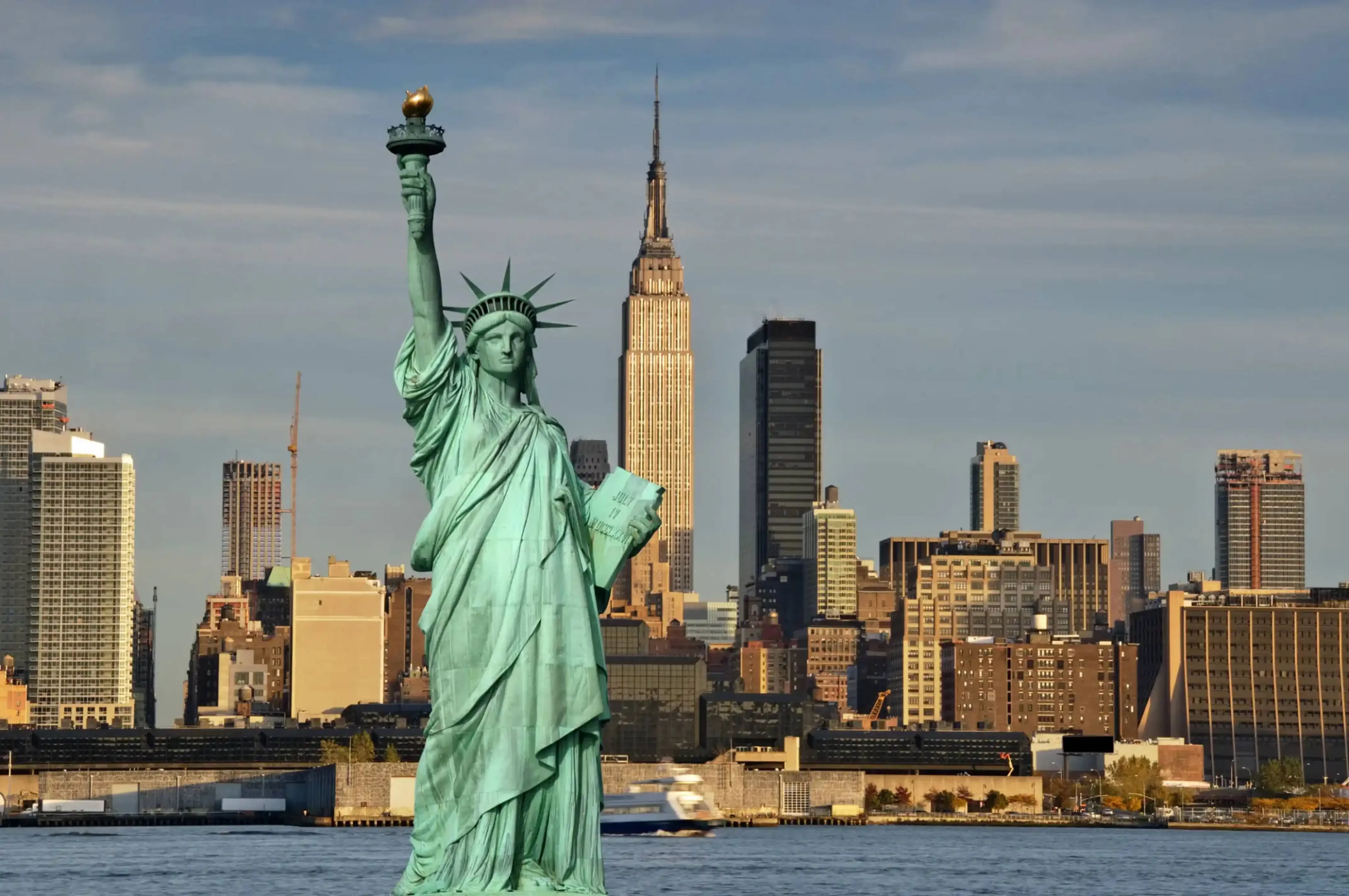 "Statue of Liberty with New York City skyline and Empire State Building in the background, USA."