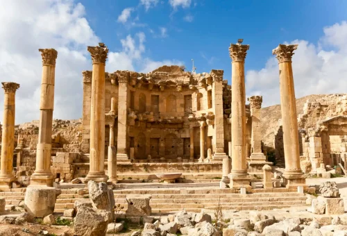 "Ruins of the Roman amphitheater and colonnades at Leptis Magna, Libya, under a bright blue sky."