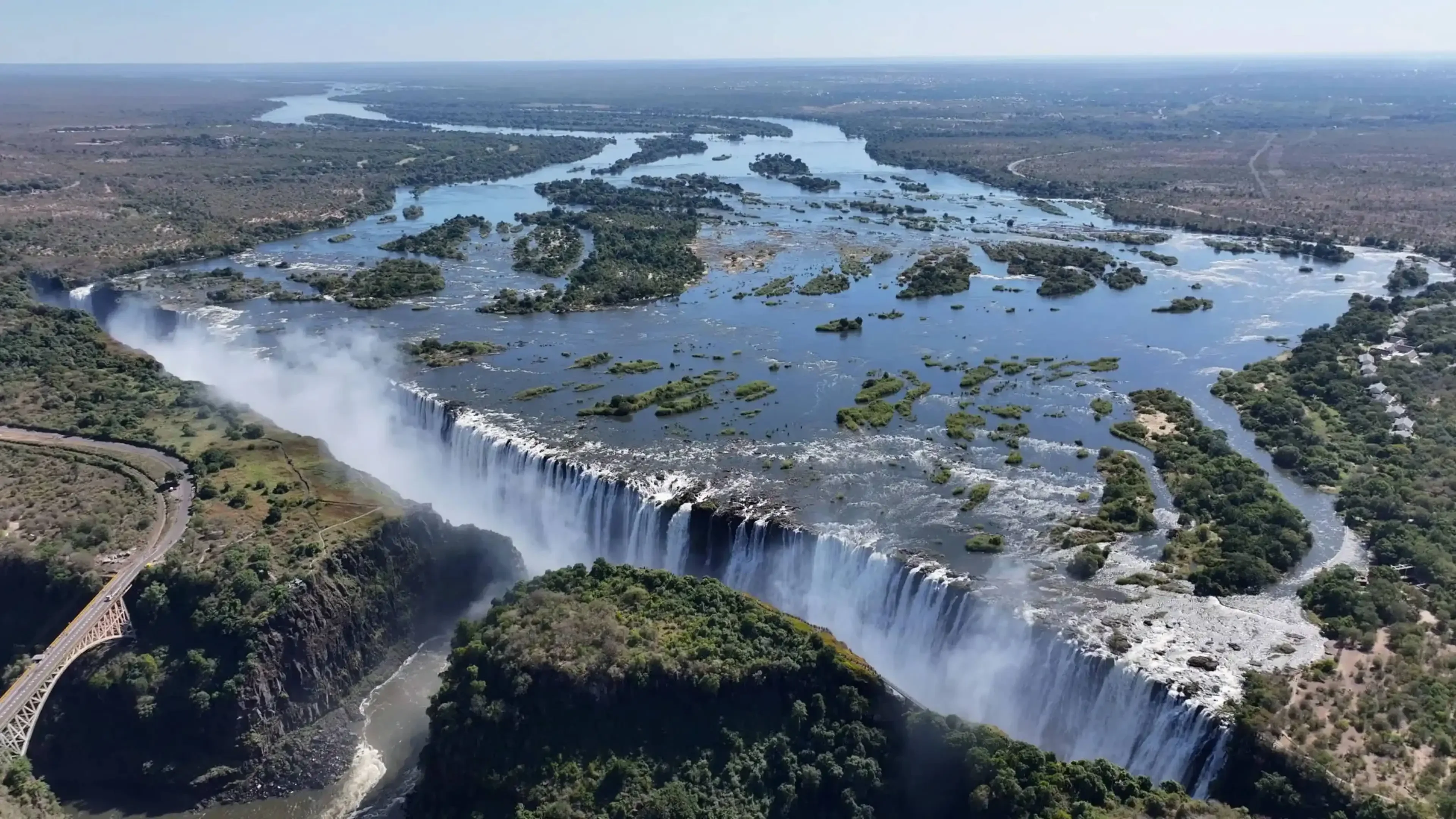 Aerial view of Victoria Falls with cascading water and surrounding lush terrain.