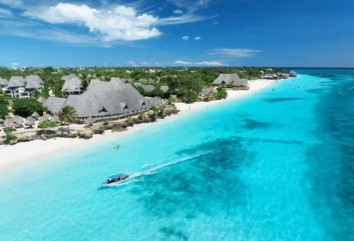 Aerial view of turquoise waters and beachfront resorts along the Zanzibar coast.