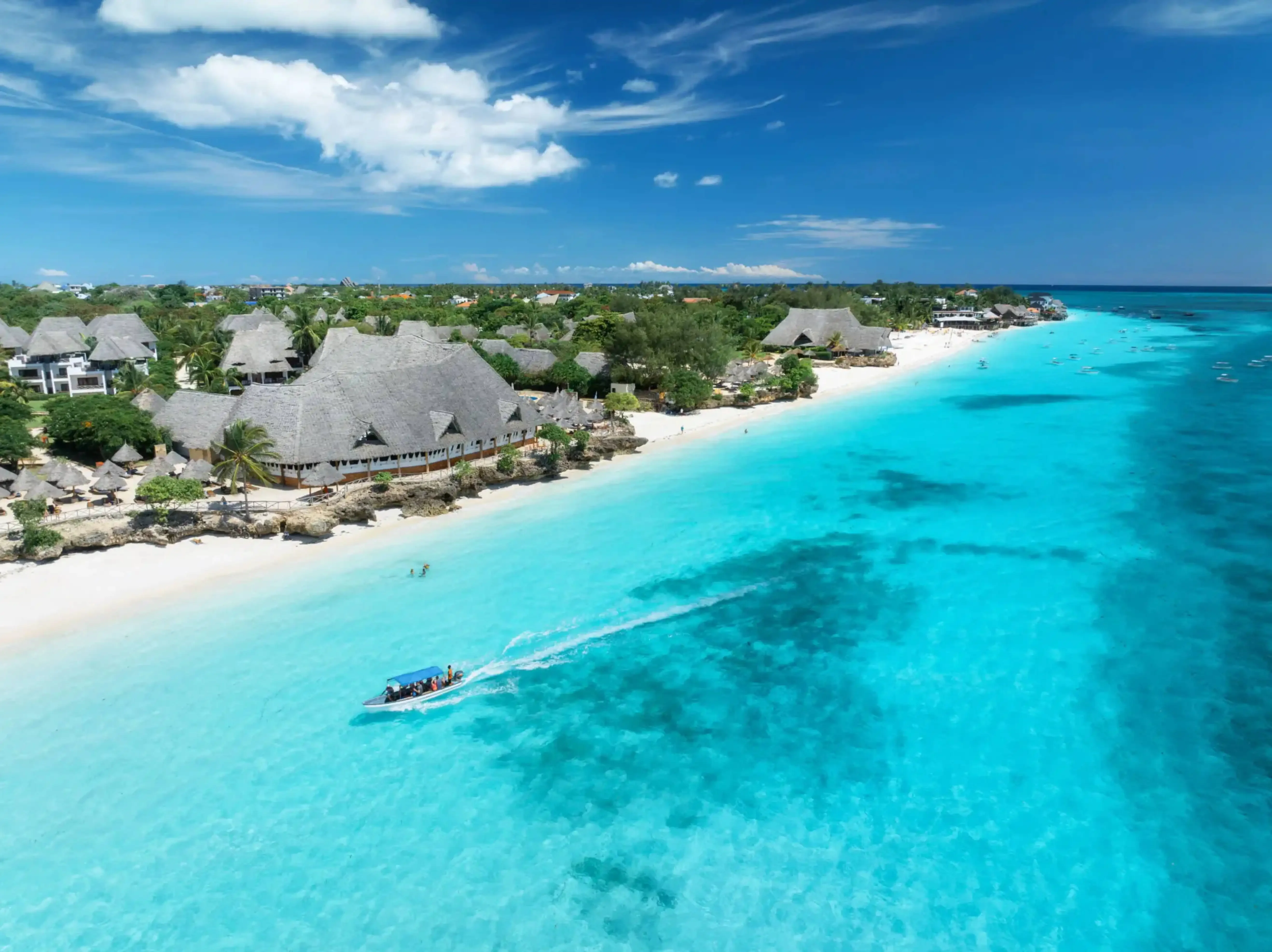 Aerial view of turquoise waters and beachfront resorts along the Zanzibar coast.