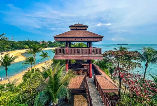 Wooden viewing pavilion overlooking the beach and lush tropical surroundings on Sentosa Island, Singapore.