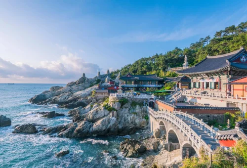 Haedong Yonggungsa Temple perched on rocky cliffs beside the ocean in Busan, South Korea.