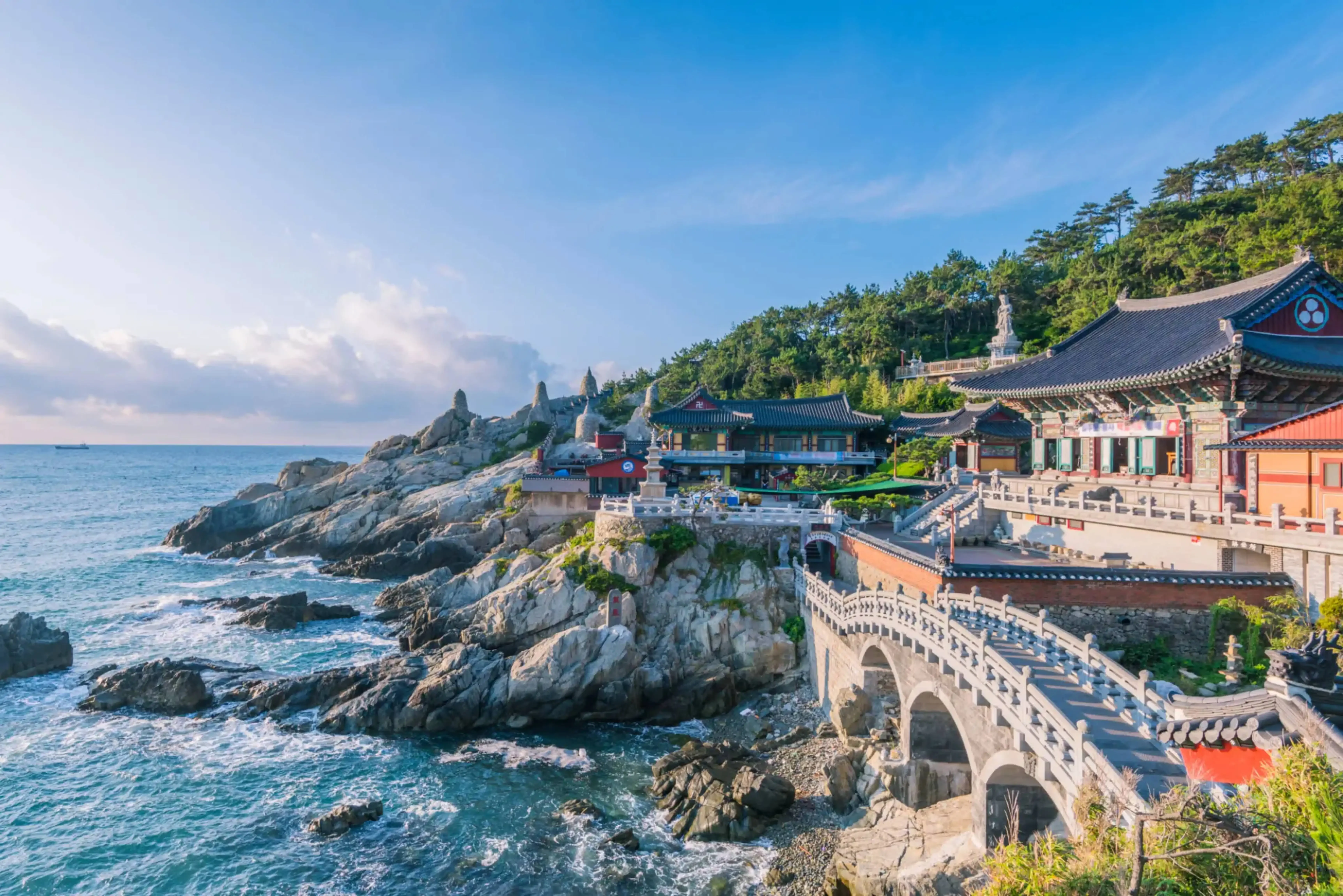 Haedong Yonggungsa Temple perched on rocky cliffs beside the ocean in Busan, South Korea.