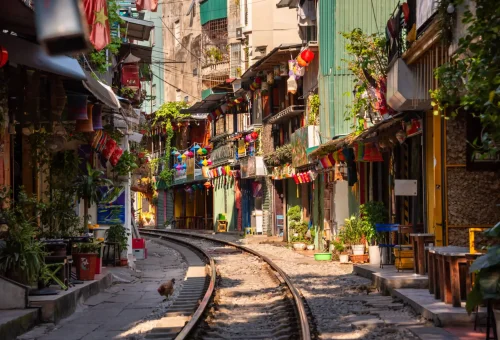 Colorful buildings and cafés line the narrow railway track running through Hanoi Train Street, Vietnam, known for its vibrant street life and passing trains.
