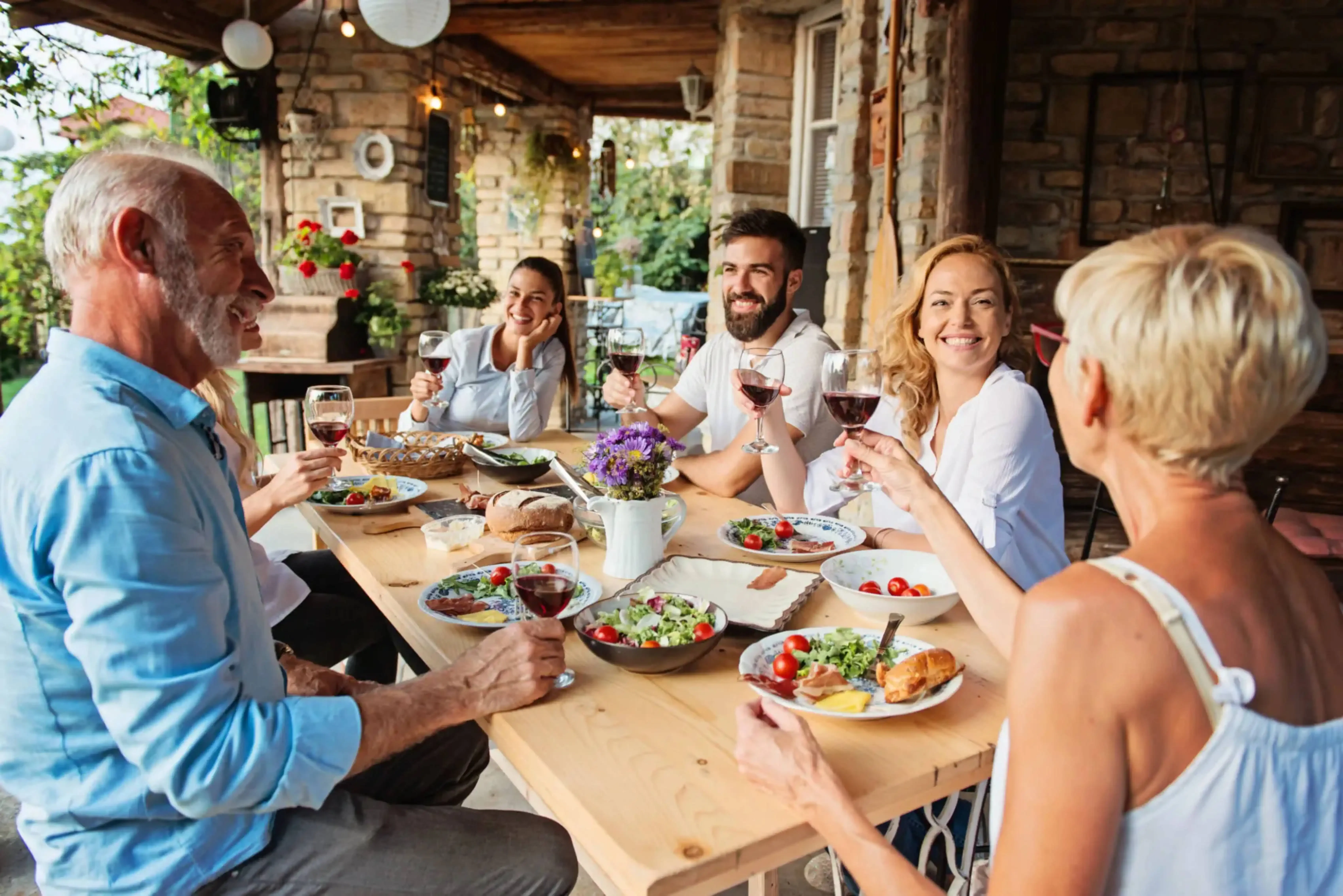 Group of happy travelers enjoying a wine and food tasting experience at a rustic countryside villa