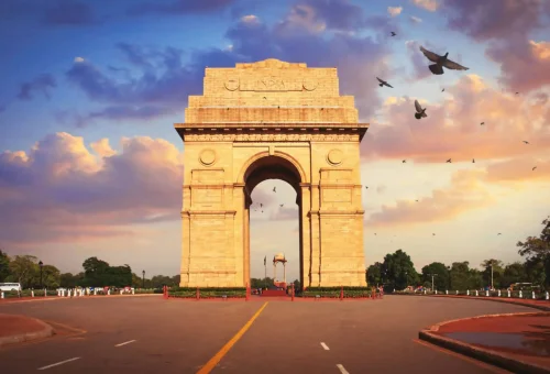 India Gate monument at sunset with flying birds in New Delhi, India