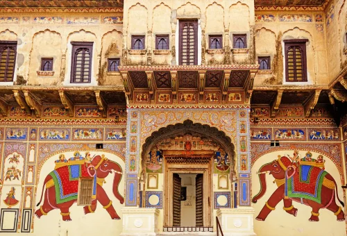 Colorful Rajasthani haveli facade with traditional elephant murals and intricate frescoes in India