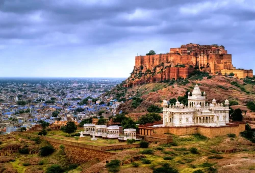 Scenic view of Mehrangarh Fort and Jaswant Thada in Jodhpur, Rajasthan, with cityscape in the background under a dramatic sky
