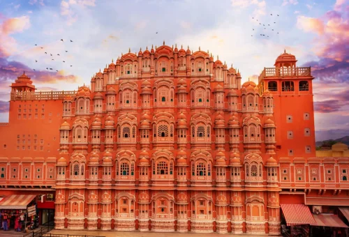 Hawa Mahal, the iconic pink sandstone palace of winds in Jaipur, Rajasthan, glowing under a colorful evening sky, Rajasthan Tours
