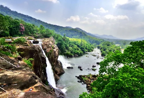 Athirappilly Waterfalls cascading into the Chalakudy River surrounded by lush greenery in Kerala, India