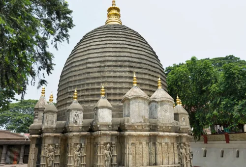 "Ancient stone temple with ribbed dome architecture and golden spire surrounded by trees"