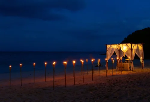 Phuket beach dinner setup flowers candles sunset