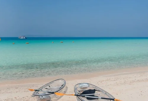 Tourists relaxing on Koh Larn Coral Island with crystal clear turquoise water near Pattaya, Thailand