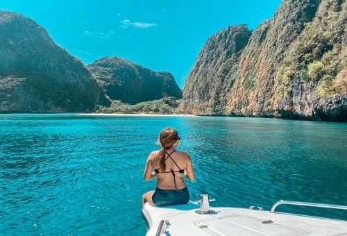 Traveler relaxing on the bow of a private speedboat in Phi Phi Islands