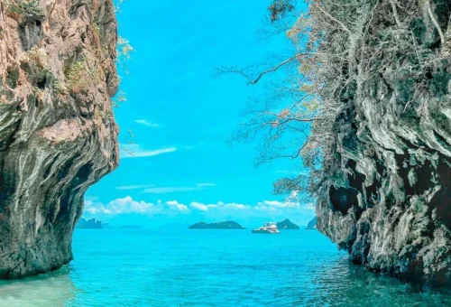 Traditional longtail boat near limestone cliffs during a Krabi island tour