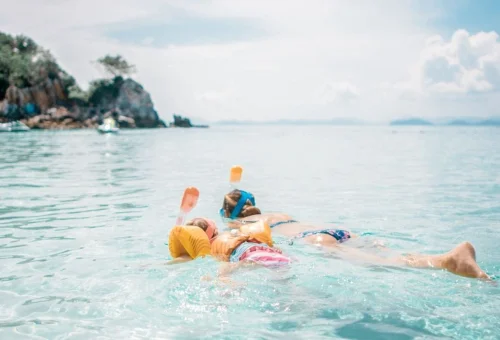 Children enjoying snorkeling in shallow water on Khai Islands family speedboat tour