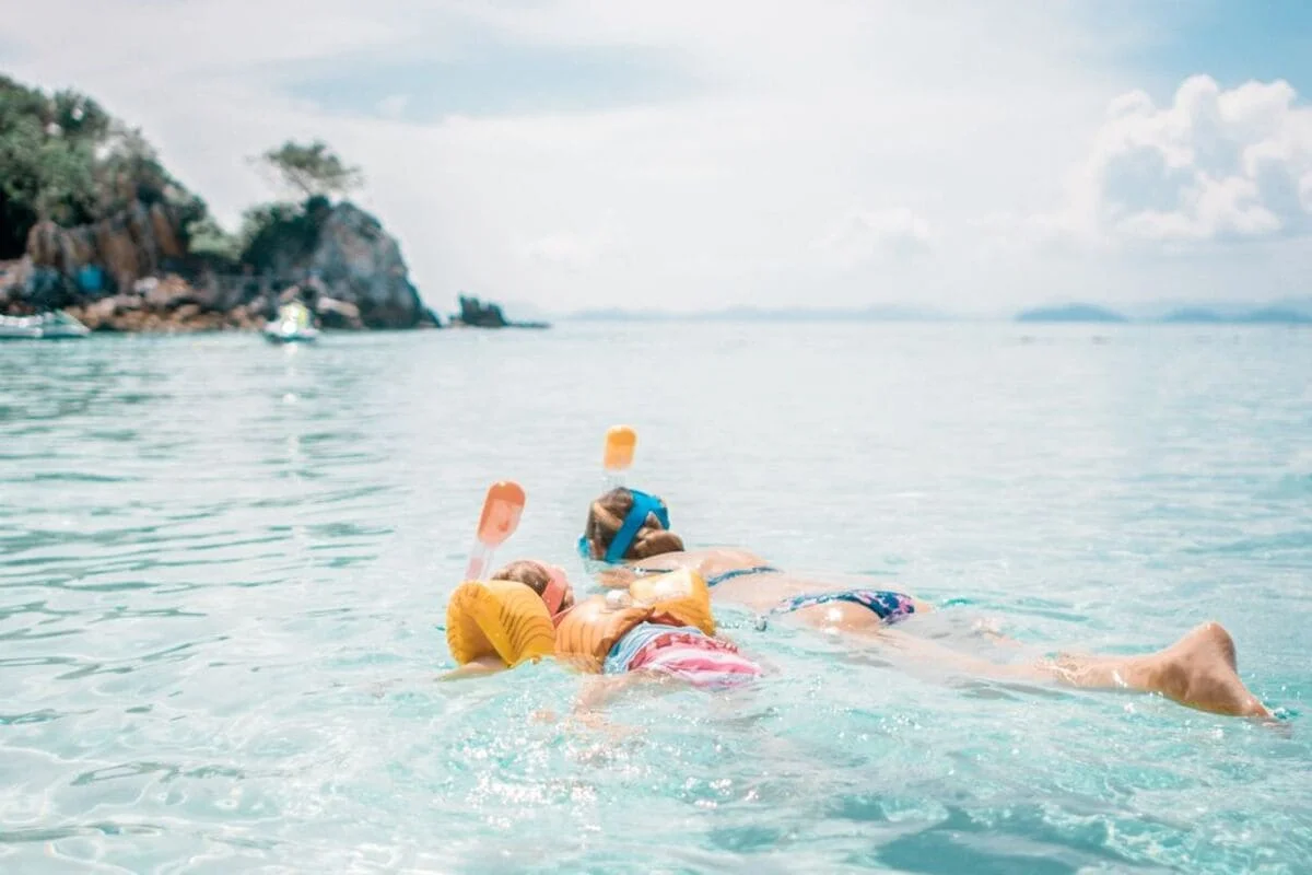 Children enjoying snorkeling in shallow water on Khai Islands family speedboat tour