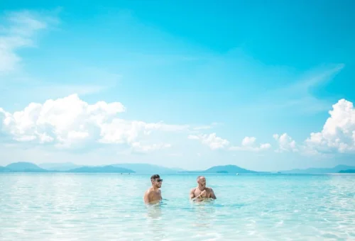 Adults swimming in shallow clear water at Khai Islands Phuket