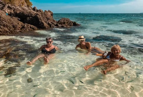 Family swimming in clear shallow water at Khai Islands Phuket