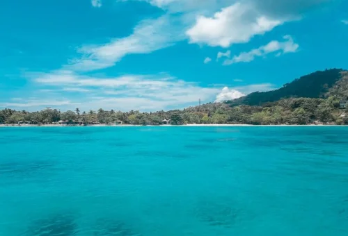 Raya Yai Island coastline and turquoise sea on Phuket island hopping tour