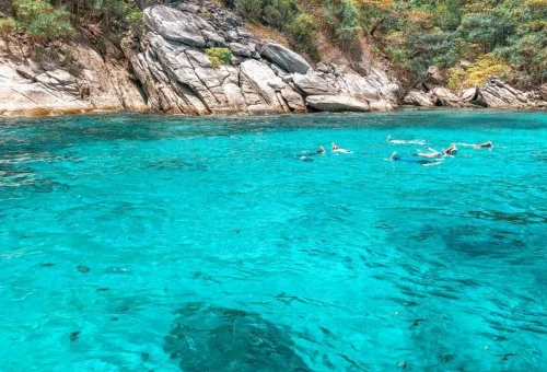 Swimming in turquoise water at Raya Noi on private Phuket island tour