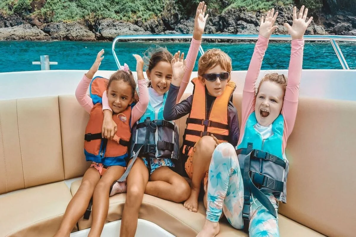 Family swimming in shallow turquoise water at Coral Island Phuket