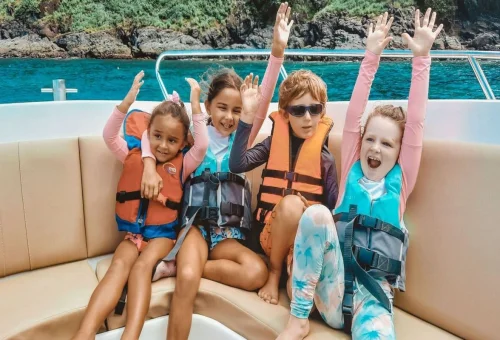 Family swimming in shallow turquoise water at Coral Island Phuket