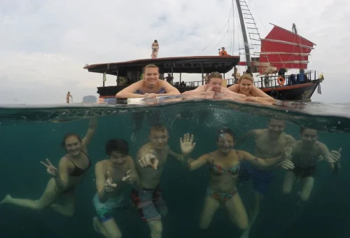 Guests swimming beside the traditional boat on the Krabi 4 Islands Sunset Cocktail Cruise