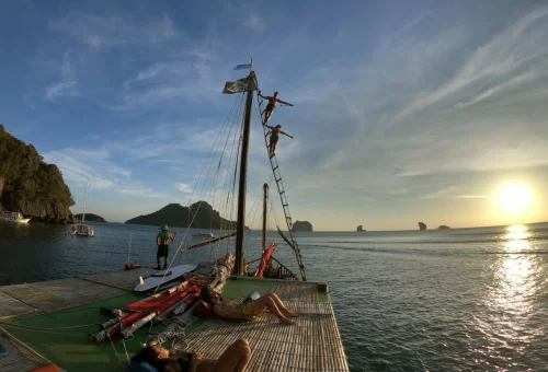 Guests enjoying an adventure on a traditional boat during sunset in Krabi