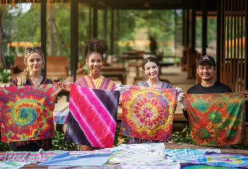 Three visitors enjoying a colourful tie-dye craft activity at Chiang Mai Elephant Jungle Sanctuary