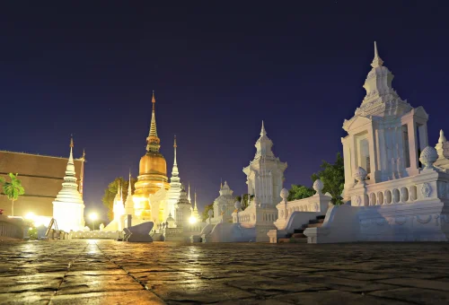 Golden chedi and white stupas at Wat Suan Dok Chiang Mai at night