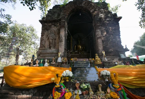 Buddhist shrine with offerings at a historic Chiang Mai temple