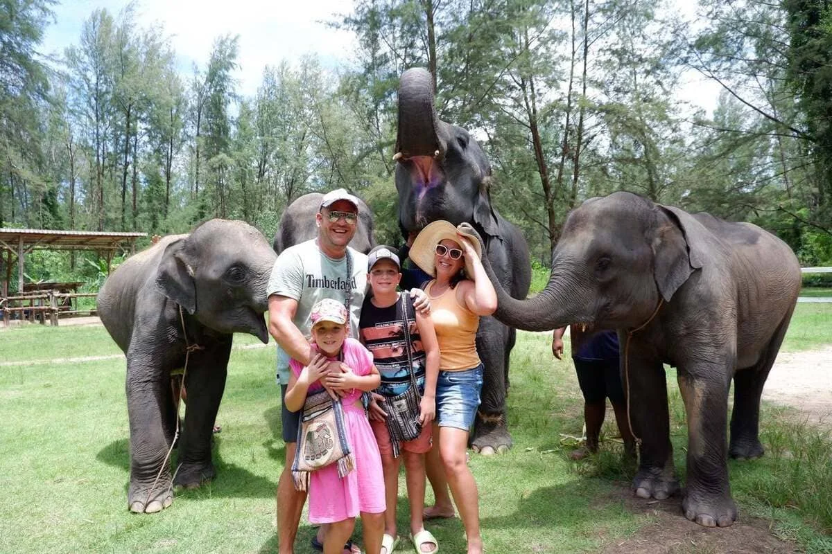 Family enjoying a Khao Lak elephant feeding experience with elephants