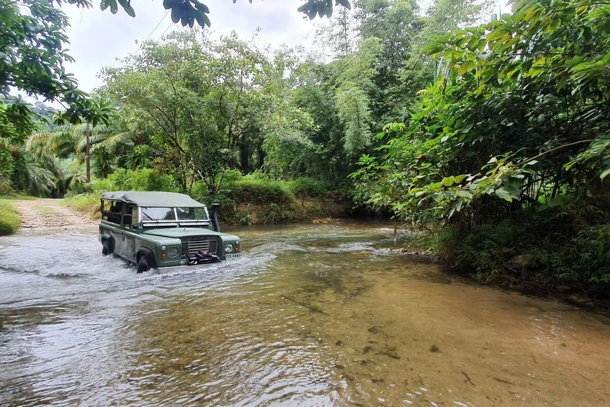Land Rover off-road jeep crossing a shallow river during a Khao Lak jungle adventure