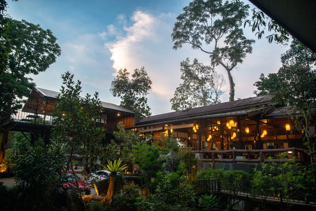 Open-air restaurant surrounded by tropical greenery at Rock and Treehouse Resort