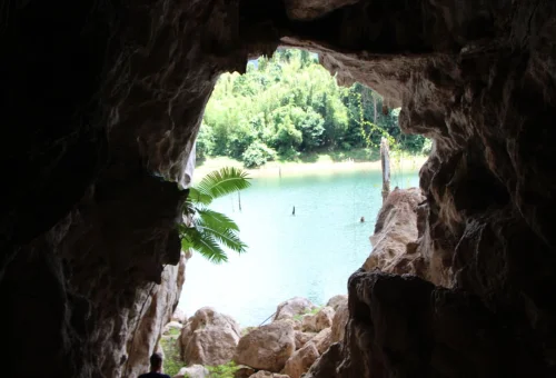 Rocky cave entrance overlooking the water in the Khao Sok lake region of southern Thailand