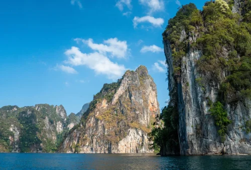 Impressive limestone cliffs rising above the emerald waters of Cheow Lan Lake in Khao Sok National Park, Thailand