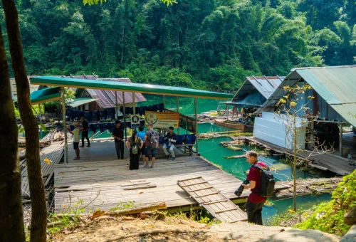 Floating raft house and wooden pier surrounded by tropical rainforest in Khao Sok National Park, Thailand